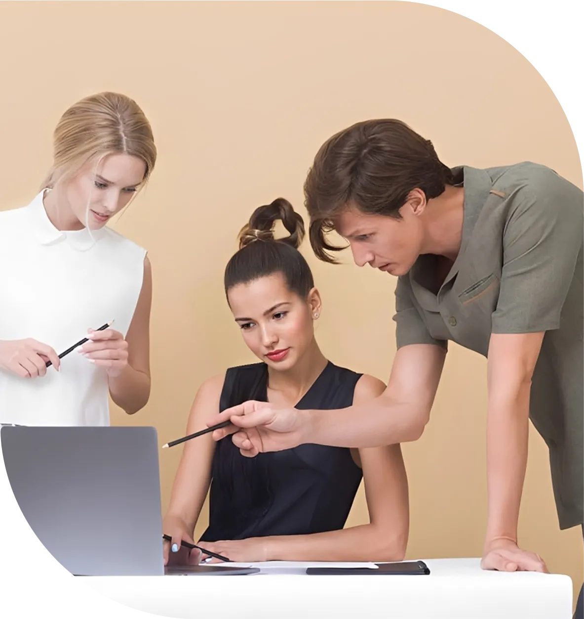 Three people collaborating at a laptop.