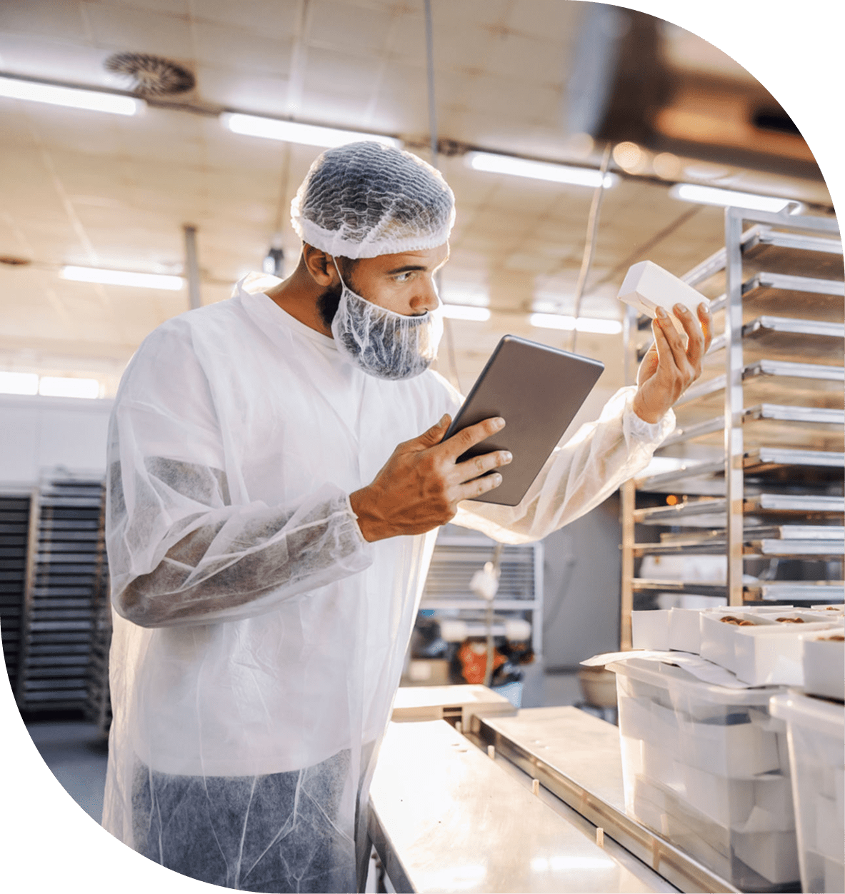 Worker inspecting goods with tablet in factory.