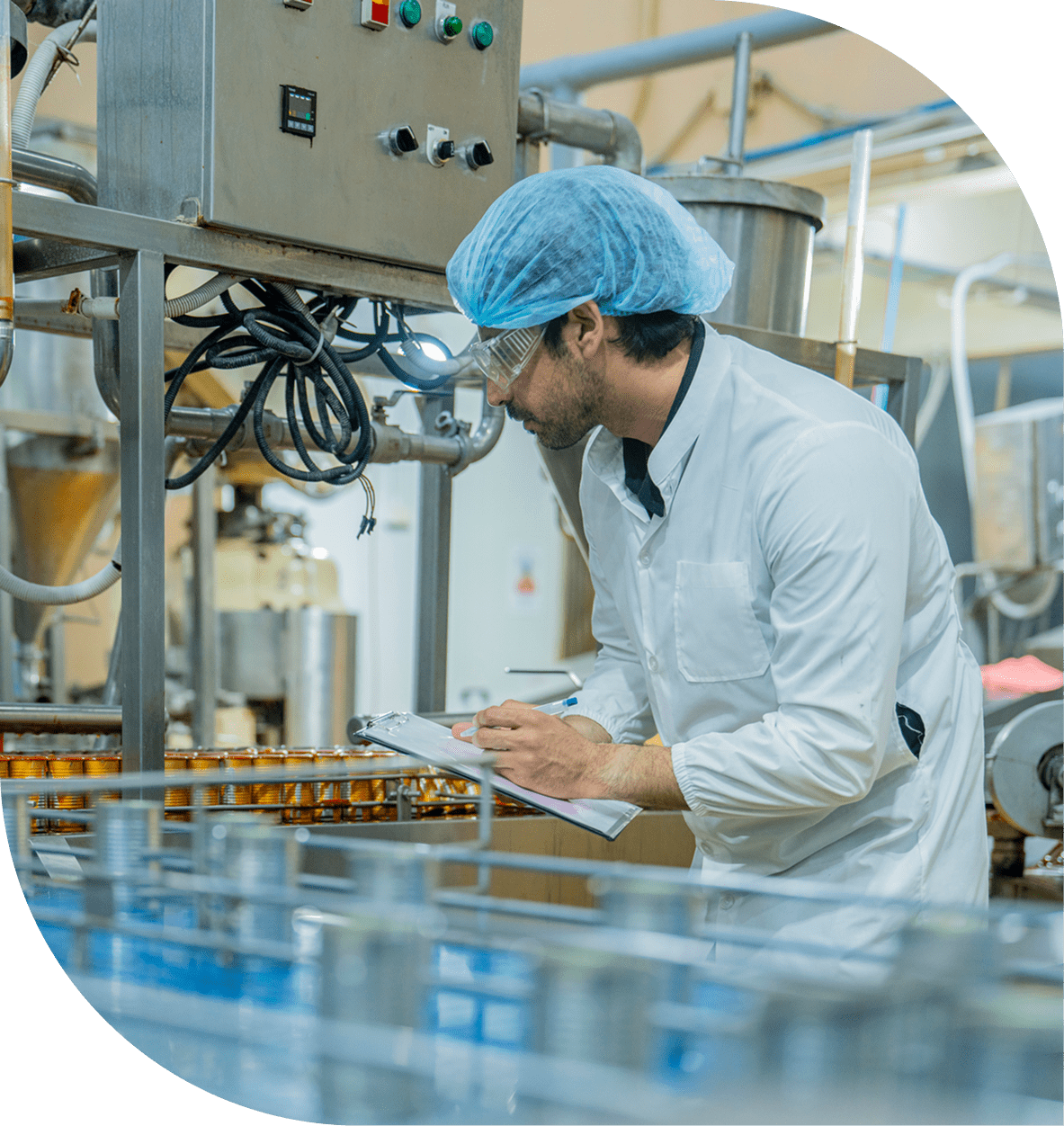 Factory worker inspecting machinery and taking notes.