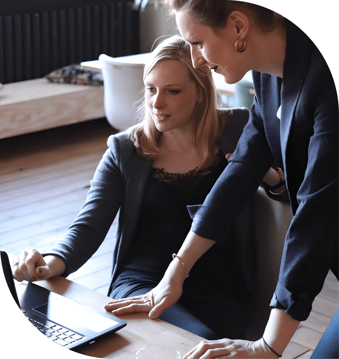 Two women collaborating at a laptop.